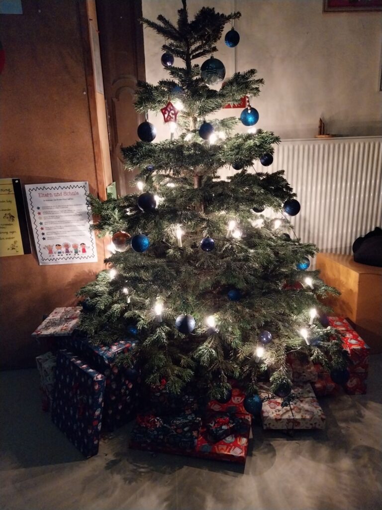 Weihnachtswichteln: Tannenbaum in der Schule mit Geschenken
